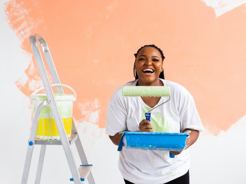 smiling-african-american-woman-painting-interior-wall-of-home-renovation-repair-and-redecoration.jpg